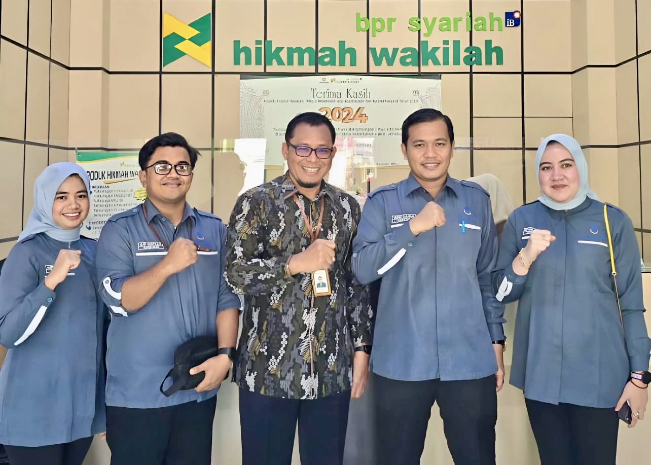 Plt Direktur LKMS Mahirah Muamalah, Dr (C) Mufied Alkamal, S.Sos.I, SE, ME beserta jajarannya foto bersama Direktur Utama BPR Syariah Hikmah Wakilah, Dr (C) Sugito, SE, ME (Tengah). Jumat, 27 Desember 2024 di Kantor BPR Syariah Hikmah Wakilah.