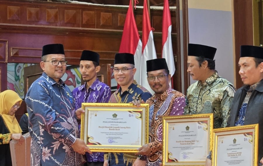 Kakanwil Kemenag Aceh, Drs. H. Azhari, M.Si menyerahkan Kemanag RI Award 2025 kepada Masjid Haji Keuchik Leumiek (HKL) yang diterima oleh Ustad Jumaris, S.Ag. Sabtu (4/1/2025) di Anjong Mon Mata Banda Aceh.