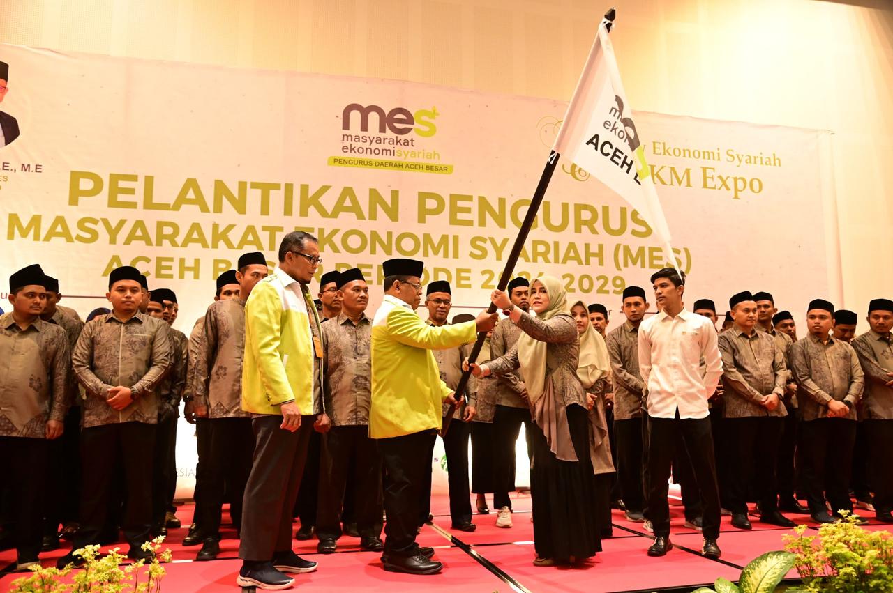 Ketua Umum MES Aceh H Aminullah Usman SE Ak MM menyerahkan pataka MES Aceh Besar kepada Amalia SE ME Ketua MES Aceh Besar yang baru dilantik, di Ballroom The Pade Hotel, Aceh Besar, Senin (19/8/2024).