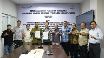 PENANDATANGANAN KERJASAMA BSPS 2026: Direktur Dana dan Jasa Bank Aceh, M. Hendra Supardi (kelima dari kiri), bersama Pejabat Pembuat Komitmen (PPK) Rumah Swadaya dan Pengembangan Kawasan Permukiman, Lukman Hakim (keempat dari kiri), menunjukkan dokumen Perjanjian Kerja Sama (PKS) Penyaluran Bantuan Stimulan Perumahan Swadaya (BSPS) Provinsi Aceh Tahun Anggaran 2026 di Kantor Pusat Bank Aceh, Banda Aceh, Kamis (12/3/2026).