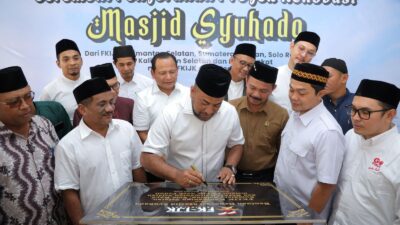 Momen penuh kehangatan saat Ketua FKIJK Aceh, Fadhil Ilyas, menandatangani prasasti peresmian renovasi Masjid Syuhada.