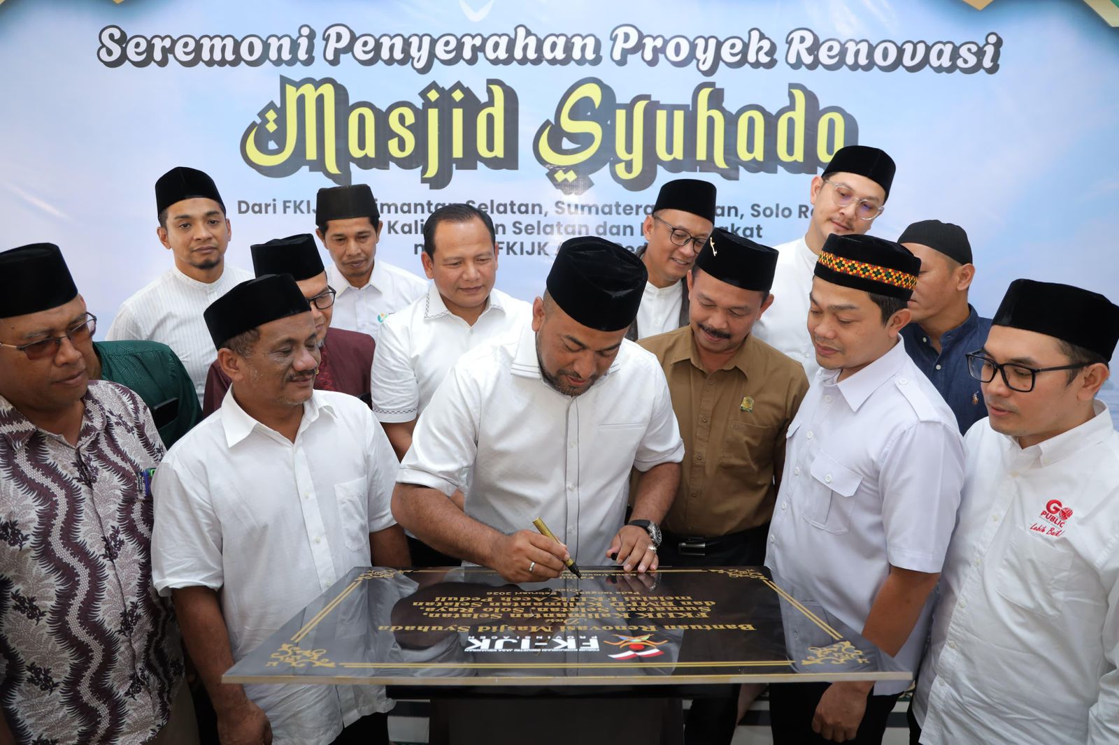 Momen penuh kehangatan saat Ketua FKIJK Aceh, Fadhil Ilyas, menandatangani prasasti peresmian renovasi Masjid Syuhada.