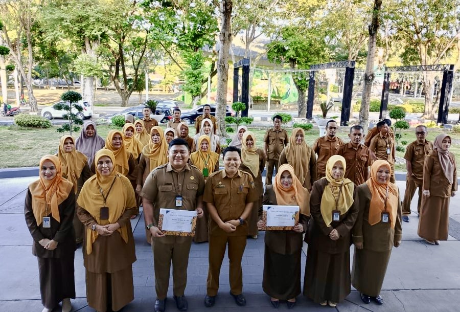 APRESIASI KINERJA: Kepala Dinas Kependudukan dan Pencatatan Sipil (Disdukcapil) Kota Banda Aceh, Heru Triwijanarko (tengah), berfoto bersama para penerima penghargaan ASN Terbaik Triwulan III dan IV Tahun 2025 beserta jajaran pegawai lainnya usai pelaksanaan apel pagi di halaman kantor setempat, Senin (9/3/2025). Penghargaan ini diberikan sebagai bentuk motivasi untuk terus meningkatkan kualitas pelayanan administrasi kependudukan yang cepat, akurat, dan ramah kepada masyarakat.
