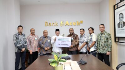 SERAHKAN ZAKAT KARYAWAN: Direktur Utama Bank Aceh, Fadhil Ilyas (tengah kanan), secara simbolis menyerahkan zakat karyawan Bank Aceh tahun 2026 sebesar Rp450.000.000 kepada Ketua Baitul Mal Aceh, Tgk. Muhammad Yunus M. Yusuf, SH (tengah kiri), di Kantor Pusat Bank Aceh, Banda Aceh, Kamis (12/03). Total zakat karyawan Bank Aceh yang disalurkan tahun ini mencapai Rp1,43 miliar yang didistribusikan ke seluruh Baitul Mal kabupaten/kota di Aceh.