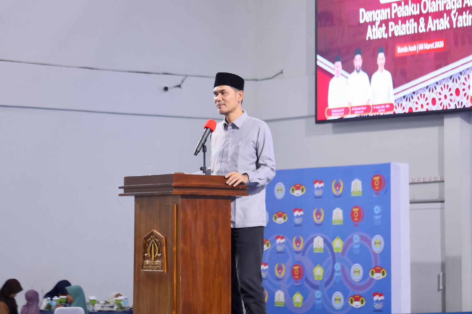 Sekda Aceh M Nasir, S.IP, MPA menyampaikan sambutan pada acara Buka Puasa Bersama KONI Aceh dengan pelaku olahraga, atlet, pelatih dan anak yatim, di GOR Persatuan Angkat Berat Angkat Besi dan Binaraga Seluruh Indonesia, Minggu (8/3/2026) sore. Turut hadir Ketua TP-PKK Aceh & Ketua DWP Aceh.