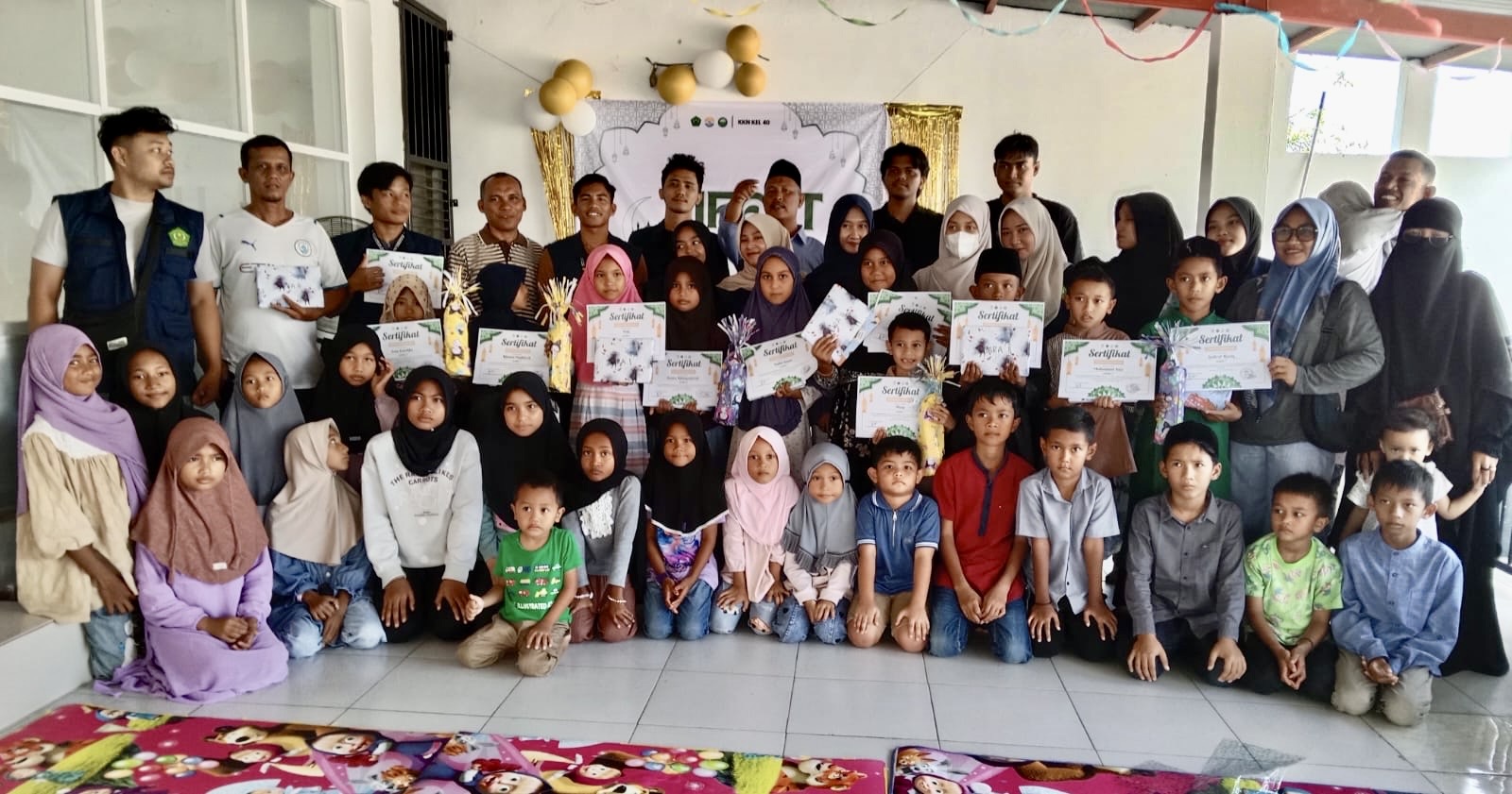 Momen kebersamaan mahasiswa KKN Kelompok 40 Universitas Abulyatama bersama perangkat gampong dan adik-adik peserta Leu Ue Islamic Festival (LIFEST) usai acara penutupan di Meunasah Gampong Leu Ue, Aceh Besar (07/03/2026).