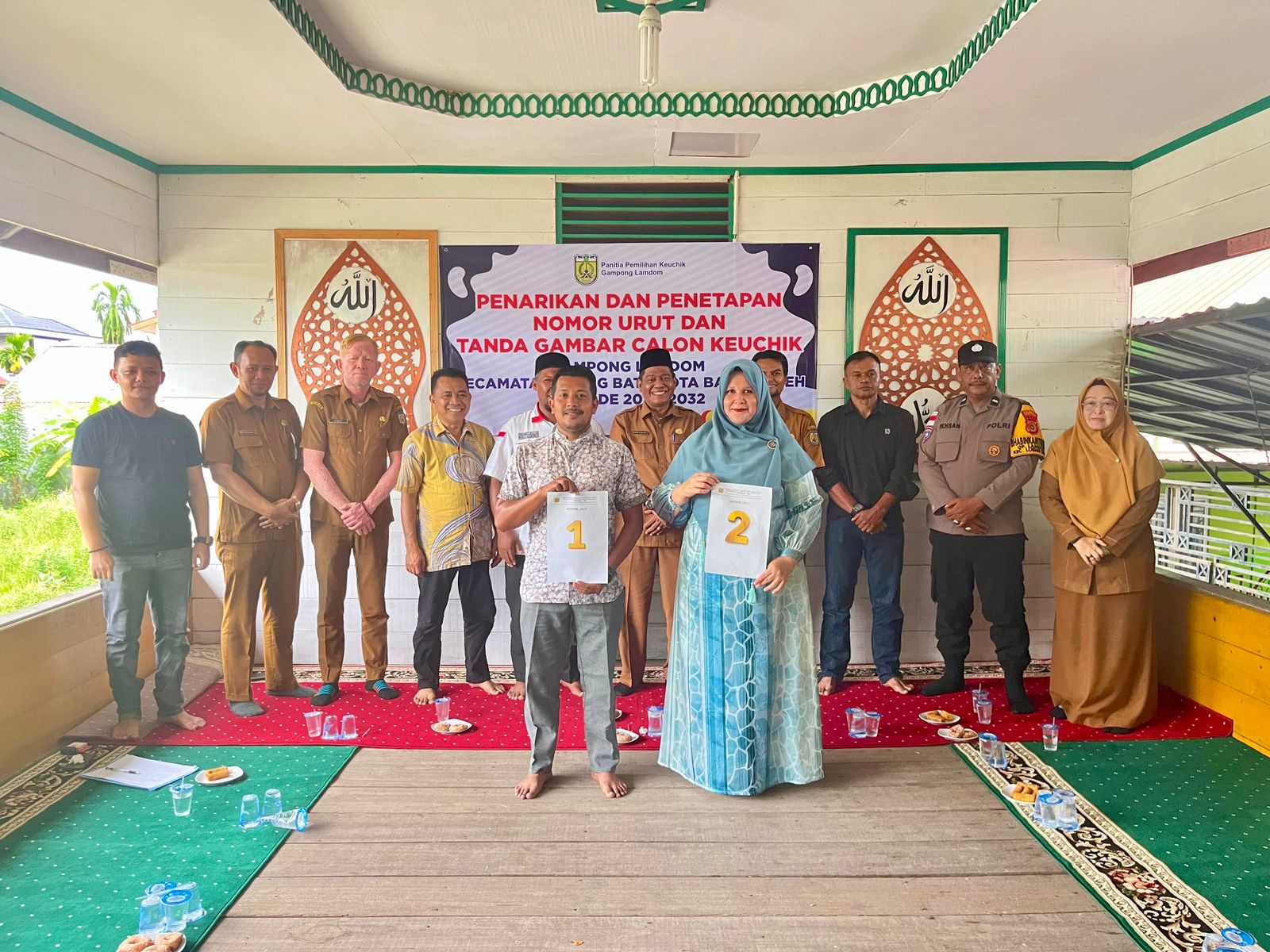 PENETAPAN NOMOR URUT. Calon Keuchik Gampong Lamdom, Al Mahidir (Nomor Urut 1) dan Nurul Naqia (Nomor Urut 2), berfoto bersama usai rapat pleno penarikan nomor urut untuk Pilchiksung periode 2026-2032 di Balai Gampong setempat, Senin (13/4/2026).