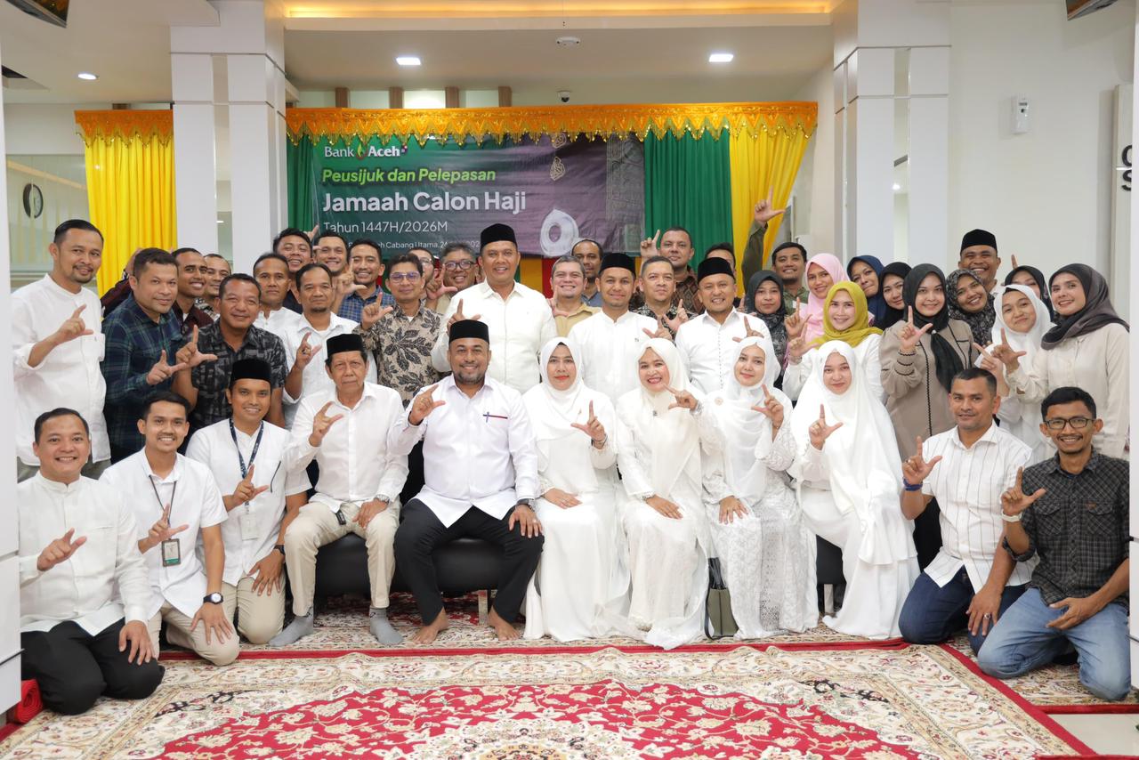 Direktur Utama Bank Aceh, Fadhil Ilyas (tengah), berfoto bersama jamaah calon haji dalam acara Peusijuk dan pelepasan 1.624 tamu Allah di Kantor Pusat Bank Aceh, Senin (21/4/2026). Selain memfasilitasi perbankan, Bank Aceh turut menjaga tradisi dan nilai spiritual nasabahnya melalui pendampingan yang menyentuh hati.